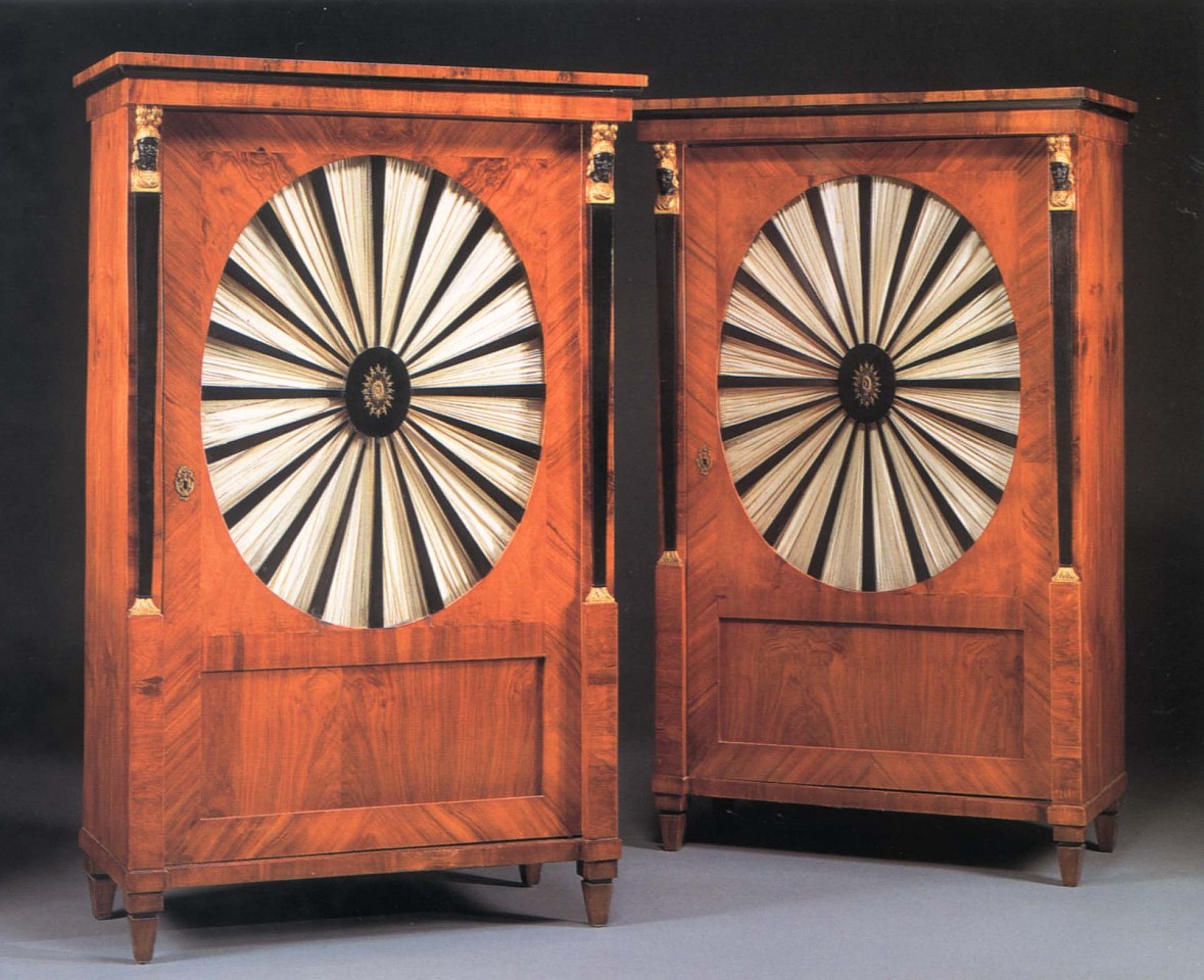 19th Century AUSTRIAN ,   Pair of Biedermeier Gilt-Metal-Mounted Black Walnut, Ebonized and Parcel Gilt Cabinets  ,  1800-1825  
  Mixed woods ,  66 1/2 x 40 1/8 x 21 in. (168.9 x 101.9 x 53.3 cm)  
  Each with a molded cornice above the cabinet door centered by an oval, glazed panel with radiating ebonized splats centered by a pierced oval mount opening to reveal shelves, flanked by military terminal supports raised on square tapering feet, now fitted with silk fabric.  
  BIE-002-FU  
   Appraisal Value : $0.00 
 Location : $0.00 
 User3 : $0.00